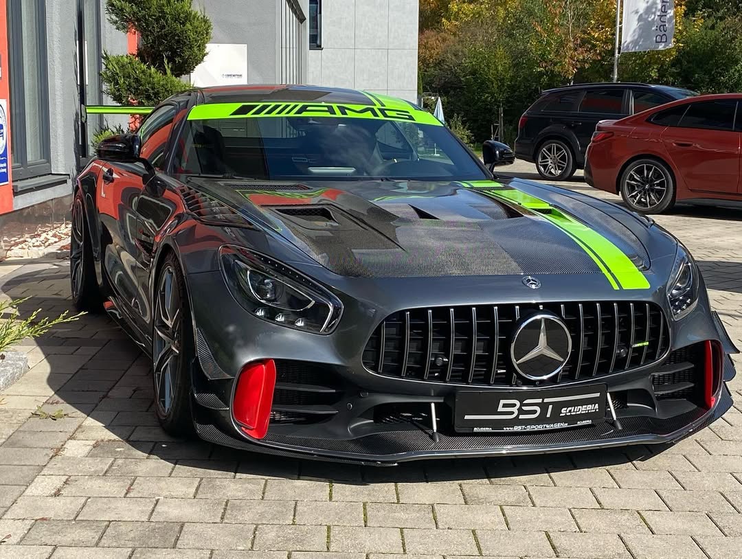 Schwarzer Mercedes-Sportwagen mit grünen Akzenten, geparkt vor einem Gebäude.