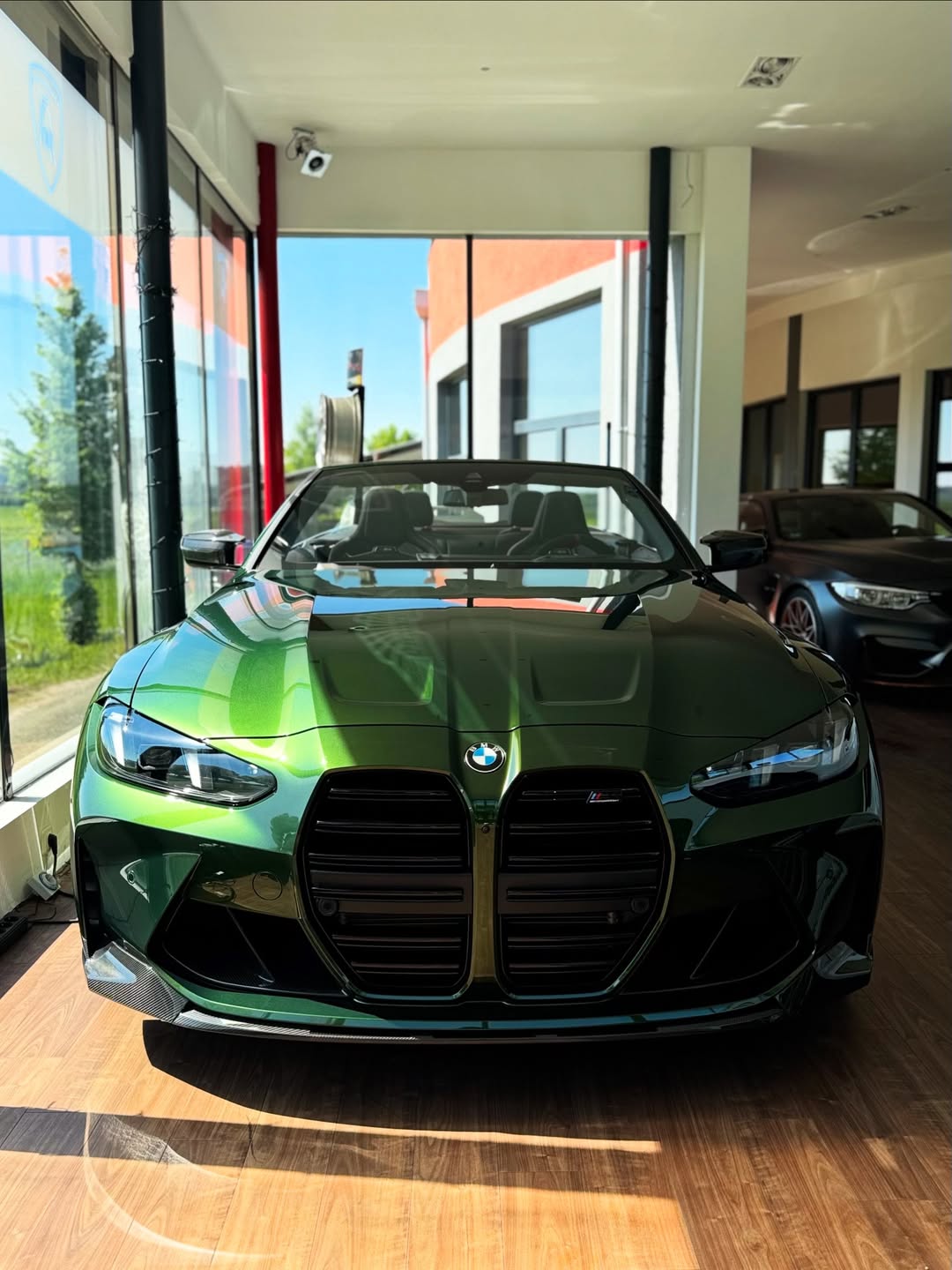 Grünes Auto mit charakteristischer Front im modernen Verkaufsraum.