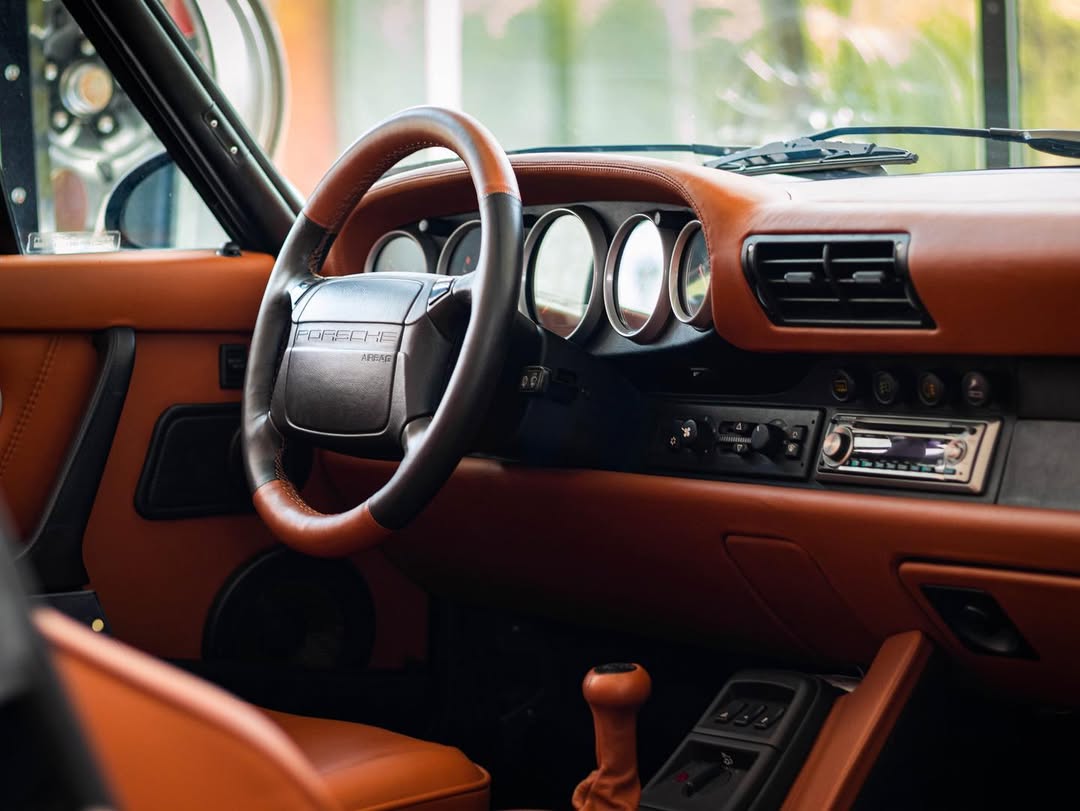 Interieur eines Autos mit braunem Leder und klassischen Instrumenten.
